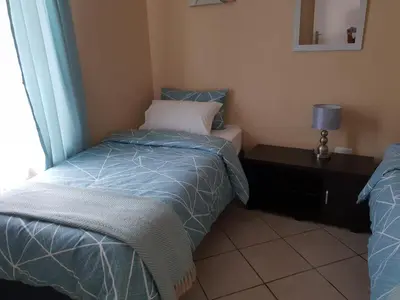 a small bedroom with a bed and a window at Clearwater Self catering Apartments No Loadshedding in Centurion