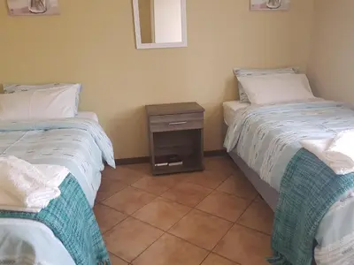 two beds sitting next to each other in a room at Clearwater Self catering Apartments No Loadshedding in Centurion