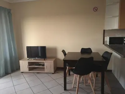 a kitchen with a table and chairs and a television at Clearwater Self catering Apartments No Loadshedding in Centurion