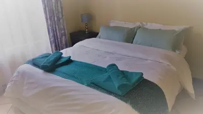a bed with two blue towels on it at Clearwater Self catering Apartments No Loadshedding in Centurion