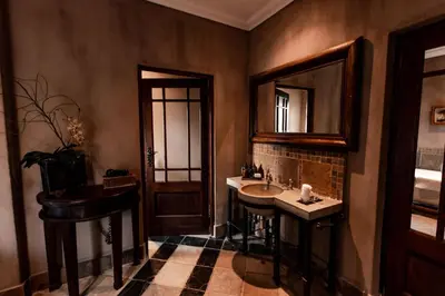 a bathroom with a sink and a mirror at Dawsons Game Lodge in Badplaas