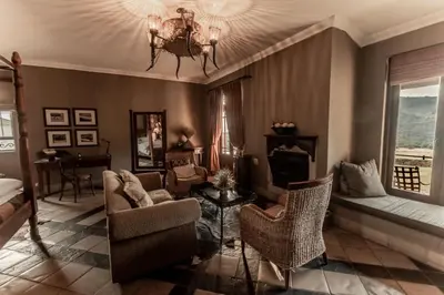 a living room with a chandelier and a couch and chairs at Dawsons Game Lodge in Badplaas