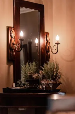 a mirror with two candles and glasses on a table at Dawsons Game Lodge in Badplaas