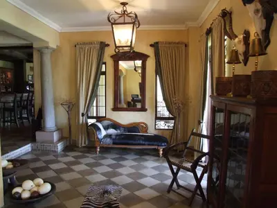a living room with a couch and a mirror at Dawsons Game Lodge in Badplaas