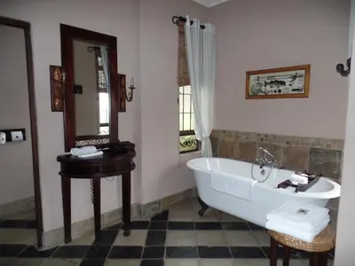 a bathroom with a bath tub and a sink at Dawsons Game Lodge in Badplaas