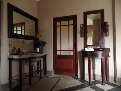 a bathroom with a door and a sink and a mirror at Dawsons Game Lodge in Badplaas