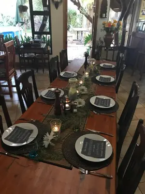 a long wooden table with black and white plates on it at Weltevreden Country Guest Lodge in Groblersbrug