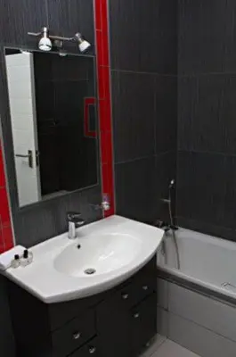 a bathroom with a sink and a mirror and a tub at Goodey's Guesthouse in Pretoria