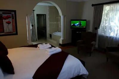 a hotel room with a bed and a tv at Goodey's Guesthouse in Pretoria