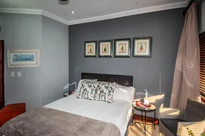 a bedroom with a bed and a chair at 7 Saint Andrew in White River