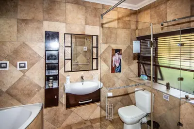 a bathroom with a sink and a toilet and a tub at 7 Saint Andrew in White River