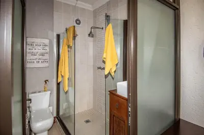a bathroom with a shower and a toilet and a sink at 7 Saint Andrew in White River