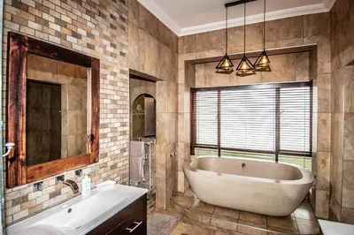 a bathroom with a tub and a sink and a mirror at 7 Saint Andrew in White River