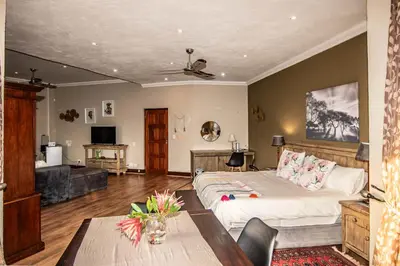 a bedroom with a bed and a table in a room at 7 Saint Andrew in White River