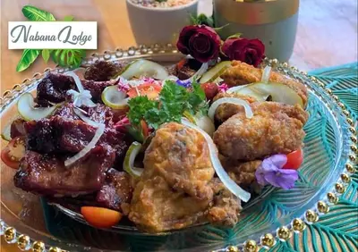 a plate of food with meat and vegetables on a table at Nabana Lodge in Hazyview