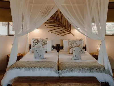 a bedroom with a bed with a canopy at Nyala Safari Lodge in Hoedspruit