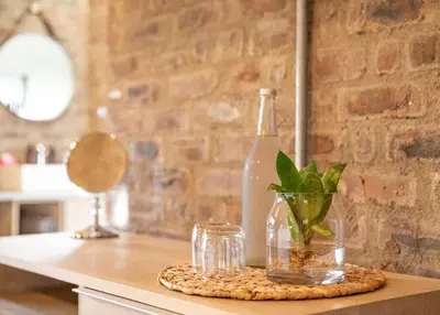 a bottle and glasses on a counter with a plant at Execustay in Nelspruit