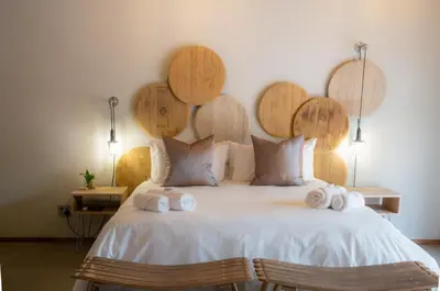 a bedroom with a large white bed with wooden headboards at Execustay in Nelspruit
