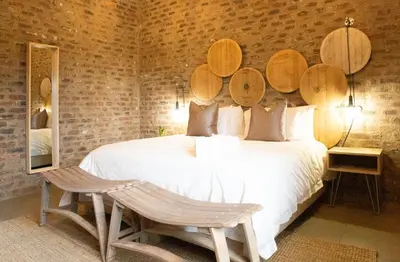 a bedroom with a large white bed with wooden headboards at Execustay in Nelspruit