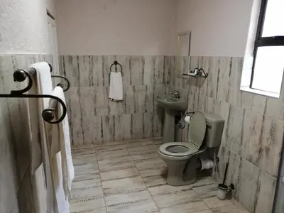 a bathroom with a toilet and a sink at Kanyane Lodge in Jane Furse