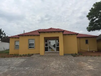 a yellow house with a red roof at Kanyane Lodge in Jane Furse
