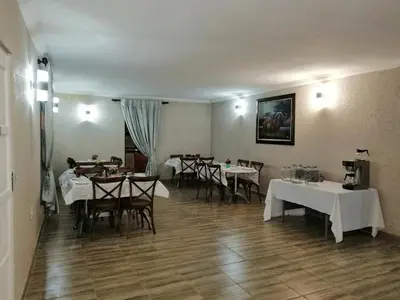 a restaurant with tables and chairs with white tablecloths at Kanyane Lodge in Jane Furse