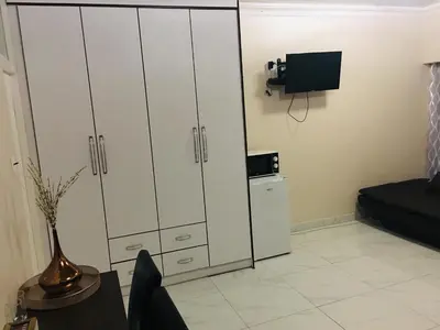 a living room with white cabinets and a tv at Riverton Manor in Centurion