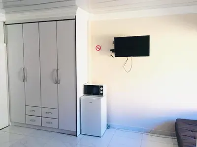 a living room with a refrigerator and a tv at Riverton Manor in Centurion