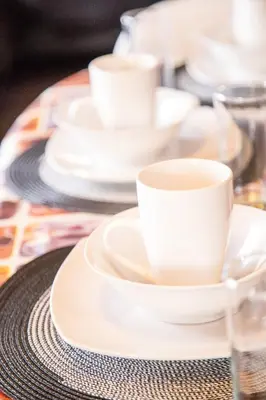 a group of white cups and saucers on a table at 29 Polvy Street in Nelspruit