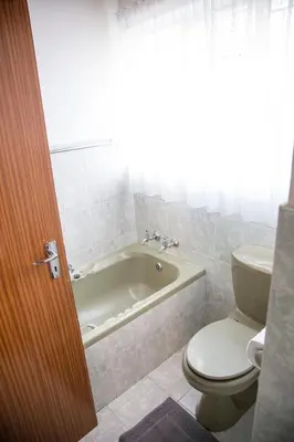a bathroom with a tub and a toilet and a sink at 29 Polvy Street in Nelspruit