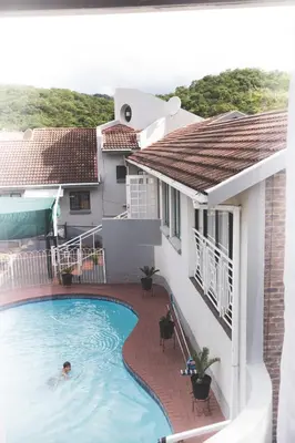 a man swimming in a swimming pool next to a house at 29 Polvy Street in Nelspruit