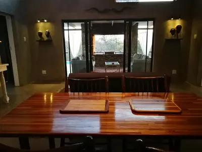 a wooden table with two plates on top of it at Kruger River Villas - LionsGate in Marloth Park
