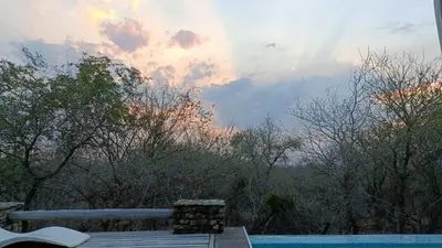 a view of a pool with trees and the sky at Kruger River Villas - LionsGate in Marloth Park