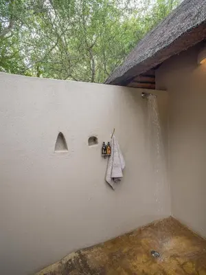 a white wall with a towel and a shower at Nyati Safari Lodge in Hoedspruit