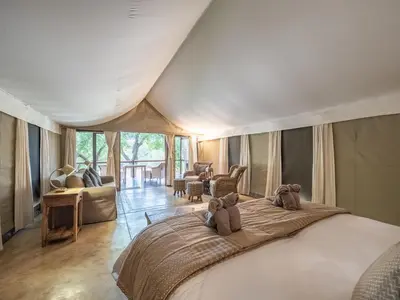 a bedroom with a bed with two teddy bears on it at Nyati Safari Lodge in Hoedspruit