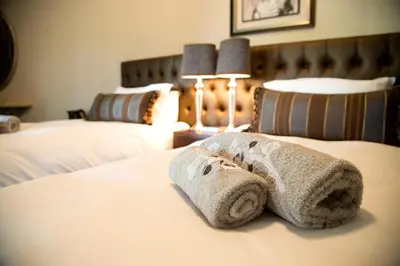 a hotel room with two towels on a bed at Bush Lovers Lodge in Modimolle