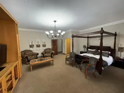 a bedroom with a canopy bed and a table and chairs at Bush Lovers Lodge in Modimolle