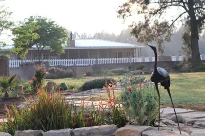 a statue of a bird standing in a garden at Rocks & Roses Farm stay in Lochiel
