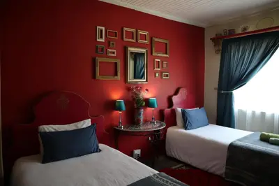 a red room with two beds and a mirror at Rocks & Roses Farm stay in Lochiel
