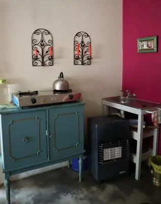 a room with a stove and a sink and a table at Rocks & Roses Farm stay in Lochiel