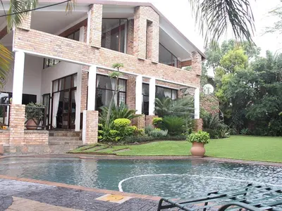 a house with a swimming pool in front of it at Stille Woning Guesthouse in White River