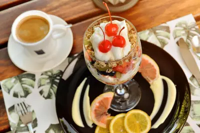 a cup of coffee and a plate of food with a dessert at Kruger Park Lodge in Hazyview