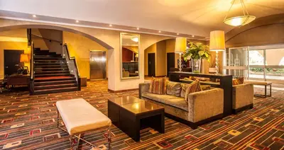 a living room with a couch and a table at Garden Court OR Tambo International Airport in Kempton Park