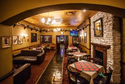 a restaurant with a fireplace and couches and tables at Garden Court OR Tambo International Airport in Kempton Park
