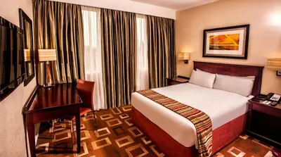 a hotel room with a bed and a desk at Garden Court OR Tambo International Airport in Kempton Park