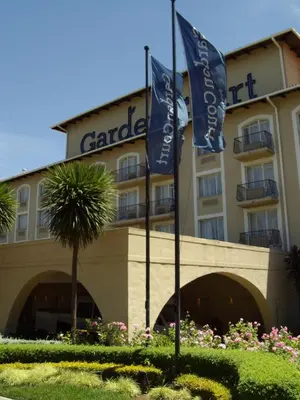 a hotel with two flags in front of it at Garden Court OR Tambo International Airport in Kempton Park