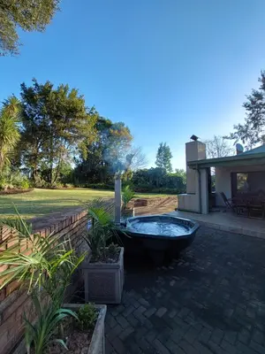 a bath tub sitting in a yard next to a house at De Mist Graskop in Graskop
