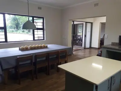 a kitchen with a table with chairs and a counter top at De Mist Graskop in Graskop