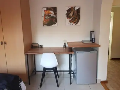 a desk in a room with a white chair at Kington Guest Suite in Pretoria