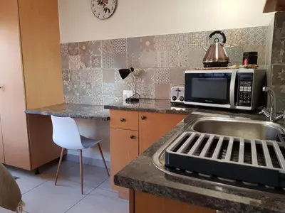 a kitchen with a sink and a microwave at Kington Guest Suite in Pretoria